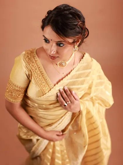 An elegant and timeless look featuring a soft brown smokey eye and a messy bun. This style is perfect for a classic saree, offering a sophisticated vibe for any formal occasion.