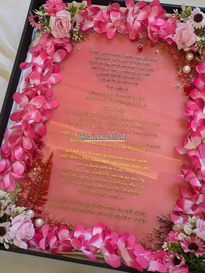 The pink resin wedding Kankotri, shown in its custom box with floral arrangements. This is how I present my special invitations to make them even more memorable.