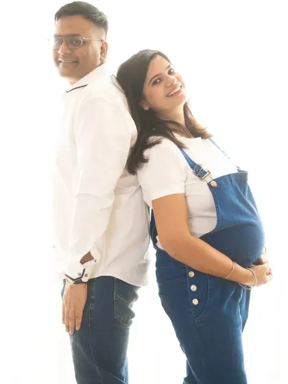 A fun back-to-back pose for this casual couple. The mom-to-be's denim overalls are a cute and comfortable option for a relaxed maternity shoot.