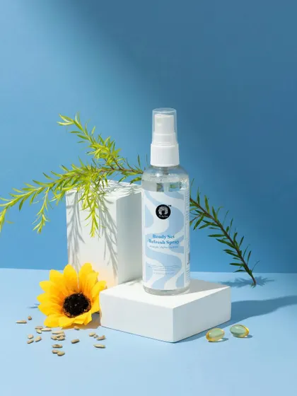A fresh, nature-inspired composition. We styled this hair refresh spray with a sunflower and botanical elements against a sky-blue background to communicate its natural ingredients and light, airy feel.