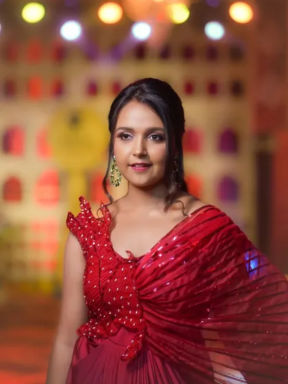 Actress Nisha Milana captured in a beautiful red outfit against a brightly lit stage. This portrait showcases my work covering television awards and red carpet events.