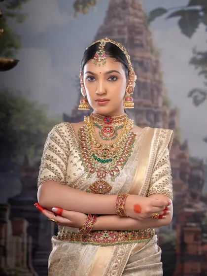 This bride embodies the grace of a goddess. The combination of the off-white silk saree, temple jewelry, and my signature makeup creates a truly divine look.