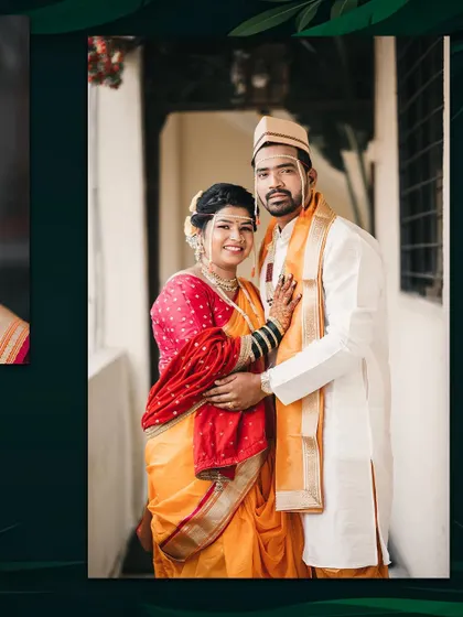 A classic portrait of a Maharashtrian couple. The bride in her vibrant Nauwari saree stands with her groom, both looking proudly at the camera.