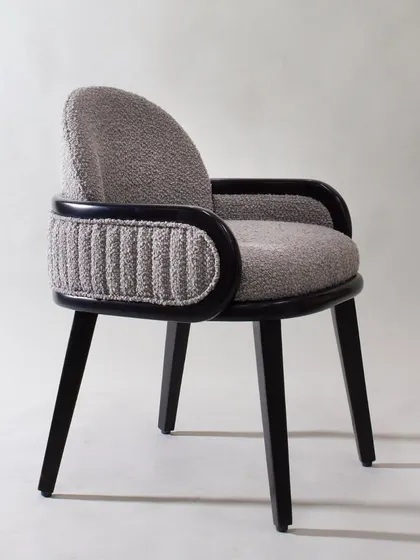 The side view of the dining/study chair shows its elegant curves and the contrast between the smooth and textured fabrics.