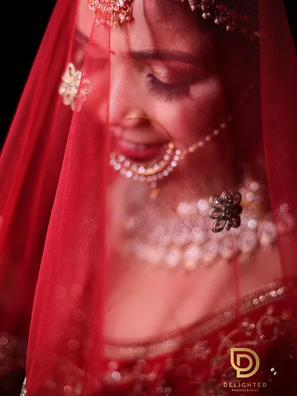A beautiful shot of the bride through her red veil. The soft focus and rich color create a classic and romantic bridal portrait.