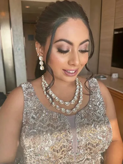 A shimmering reception look with soft purple eyeshadow and a layered diamond necklace.