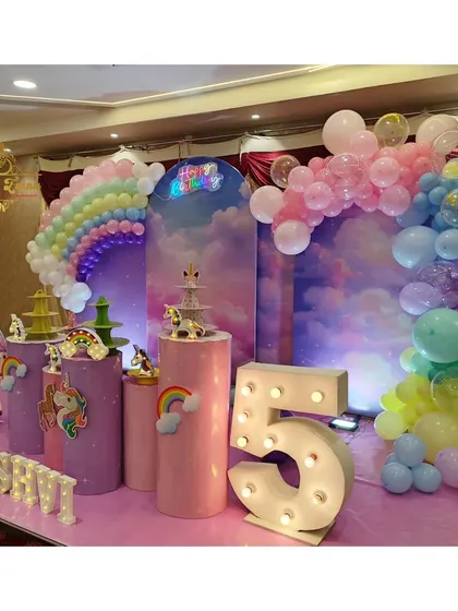 Another angle of the unicorn party, showcasing the flying unicorn prop and rainbow details on the plinths.