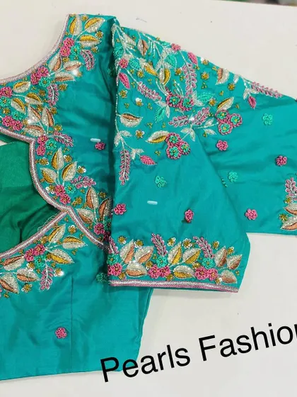 A floral-themed heavy work blouse in turquoise. I used a mix of thread, beads, and sequins to create a colorful and detailed garden pattern across the entire piece.