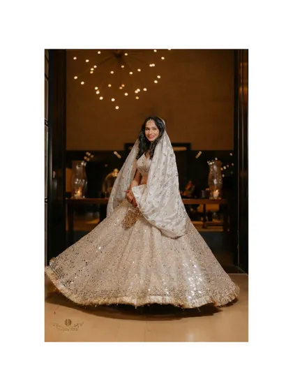 A stunning shot of the bride twirling in her magnificent, sparkling lehenga. The movement and joy are palpable in this beautiful portrait.