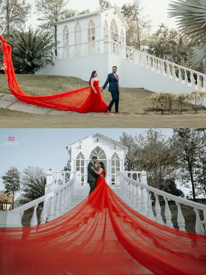 A dramatic and cinematic shot featuring a vibrant red trail gown against a white chapel-like structure, creating a powerful visual.