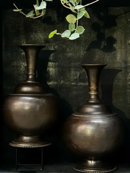 A pair of large copper vases with a beautiful vintage finish. Their exquisite shape and form make them perfect for an entryway or on end tables, either together or on opposite sides for symmetry.