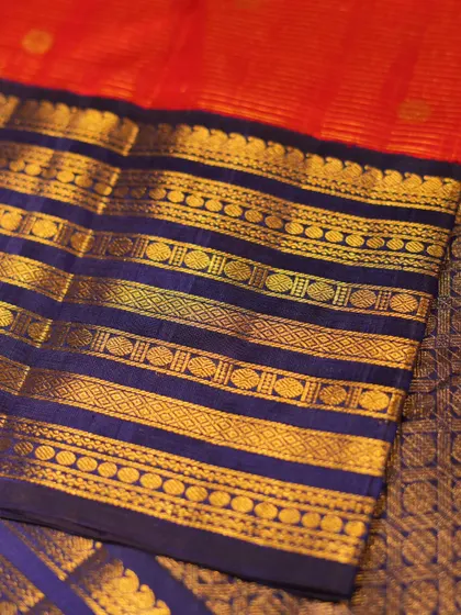 The interplay of red, blue, and gold in this Kanjivaram is a classic combination, perfect for a traditional wedding ceremony.