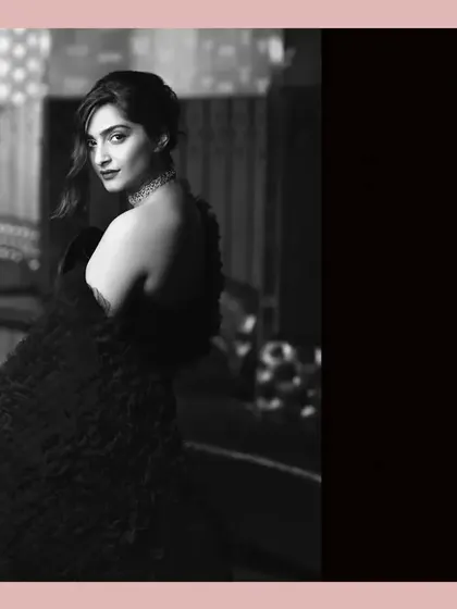 The ever-stylish Sonam Kapoor. This black and white portrait has a classic, old-world glamour feel. The lighting creates a soft focus on her, while the rich textures of her outfit add depth and sophistication.