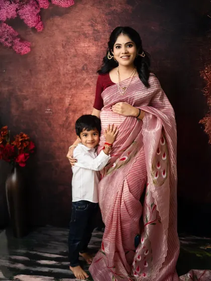The joy of an older sibling. This sweet moment captures a young boy hugging his mother's baby bump, a beautiful memory for a growing family in a traditional setting.