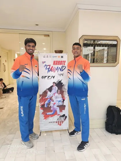 My students Rajat Kashyap and Harshit Pandey standing in front of the official banner for the Thailand Open Karate Championship. This is where they prepare to represent India.