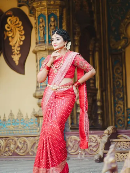 This look is fit for a queen, combining a classic red saree with traditional gold jewellery.