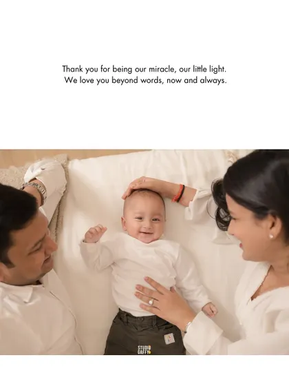 A beautiful overhead shot of parents looking down at their smiling baby, a moment of pure connection.