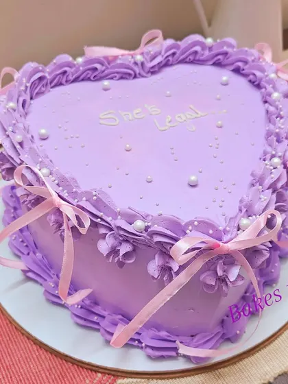 The same "She's Legal" 18th birthday cake, adorned with delicate pink ribbons for an extra pretty, coquette-style finish.