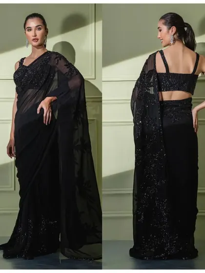 A timeless black georgette saree featuring delicate tonal floral embroidery. The strappy blouse adds a contemporary touch to this classic piece.