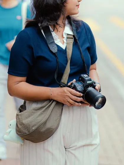 A close-up shot of me with my Nikon camera in Hong Kong. This photo highlights the professional gear I use on my travel assignments.