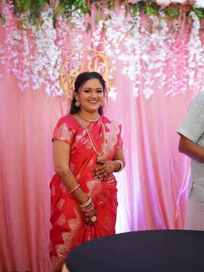 A beautiful standing portrait of the bride in her red engagement saree. The makeup is balanced to look stunning against the vibrant color of her outfit.