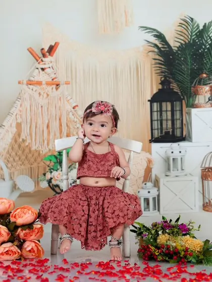 A sweet baby girl sitting in a chair amidst a boho-themed setup. This shot shows the versatility of the theme, perfect for portraits before or after the splash.