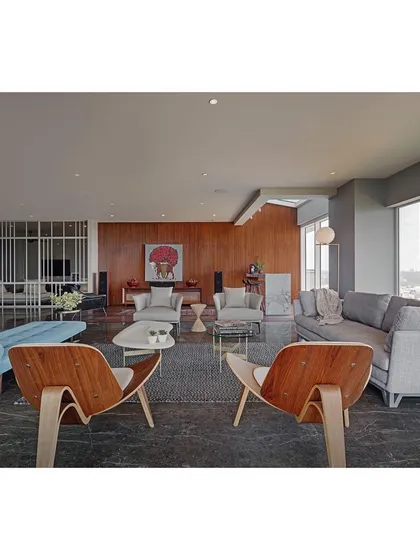 The living room at Sky Residence, designed as a sophisticated space for entertaining. I used a mix of iconic pieces, like the Eames lounge chairs, with comfortable modern sofas and a dark marble floor to create a layered, mid-century inspired aesthetic.