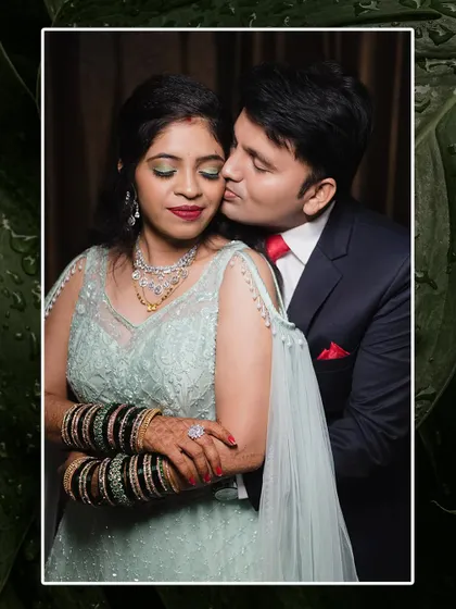 A sweet and romantic pose from an engagement shoot. The groom embraces his fiancée from behind and gives her a gentle kiss on the cheek.