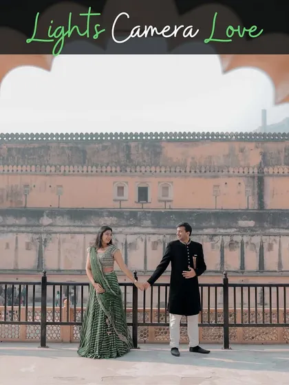 A grand, wide-angle shot of a couple holding hands against the backdrop of a magnificent Jaipur palace, perfectly capturing the "Lights, Camera, Love" theme.