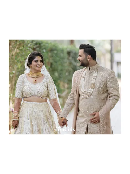 A classic couple portrait, holding hands and sharing a look of love. Their coordinated outfits and happy smiles make for a perfect, timeless wedding photo.
