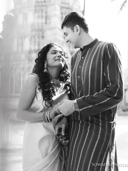 A timeless black and white portrait from a pre-wedding shoot. The couple shares a look of love against the soft-focus background of a temple.