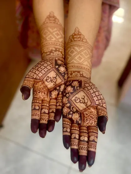 The rich, dark stain of the baby shower mehendi with Kannada script, showing the quality of the natural henna.