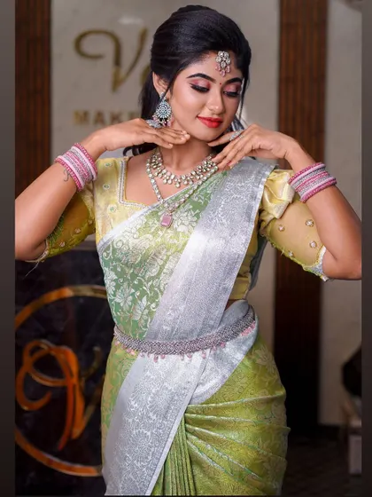 A light green and silver saree that creates a very fresh and modern look. The draping is soft and elegant, suitable for a daytime event or reception.