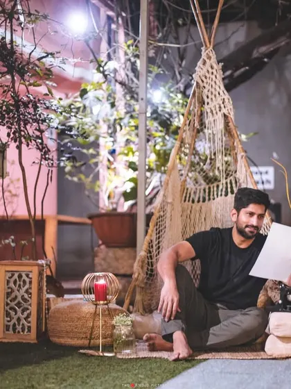 A candid shot of a man waiting for his partner in a beautifully styled boho proposal setting, complete with a teepee, candles, and a vintage typewriter for a love note.