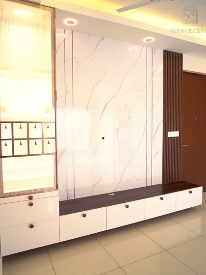 A modern TV unit featuring a white marble back panel with dark wood fluting and an integrated pooja unit with a fluted glass door. This multifunctional design is both stylish and space-efficient.