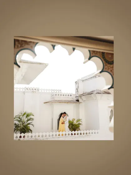 A distant shot capturing the couple against the grand architecture of Udaipur.