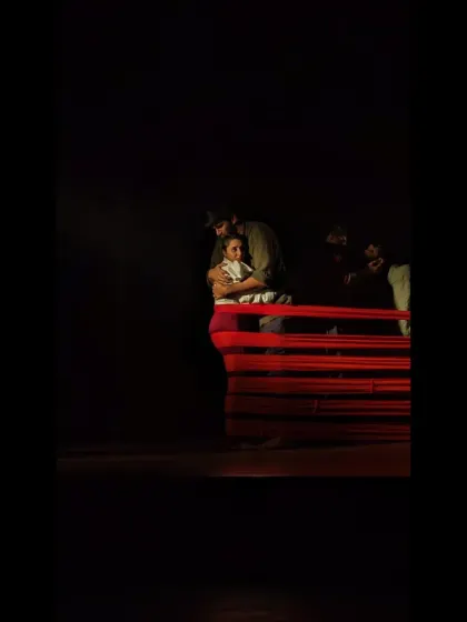 A quiet, intimate moment from 'Sea's Fire', where two performers share a connection amidst the larger story.