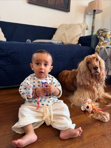 Pablo and Posto sitting together after the Rakhi ceremony, surrounded by their toys and gifts.