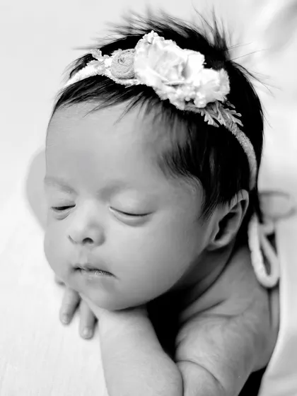 A black and white version of the classic 'chin on hands' pose, emphasizing the peaceful expression and soft textures.