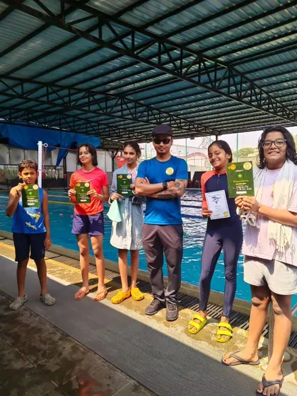 Our intermediate and advanced swimmers proudly hold their certificates after completing their summer camp. They've worked on all four strokes and improved their skills.