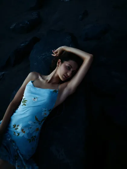 An intimate portrait against dark, textured rocks. The soft, fading light of sunset creates a beautiful, painterly quality.