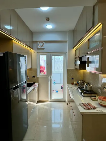 A complete view of the parallel kitchen, showing the layout from one end to the other. The lighting design ensures the entire length of the kitchen is well-lit.