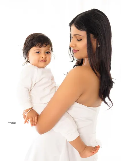 A classic mother and child portrait against a clean white background. The simplicity of the shot highlights their connection.