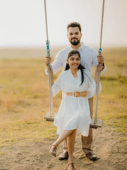 A fun and classic pre-wedding photo on a rustic swing. This shot of Milan and Pranali is playful and sweet, capturing a lighthearted moment.