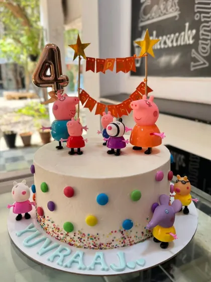 A fun Peppa Pig party on a cake! This design features the whole family as figurines on a simple, colorful polka-dot cake, perfect for a young child's 4th birthday.