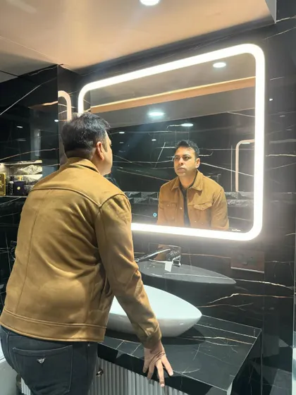 The large, backlit mirror is a key feature, providing excellent lighting for the vanity area.