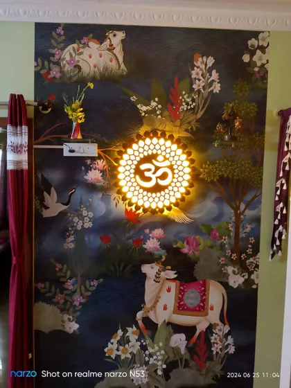 A beautiful Pichwai-style mural featuring cows and the Om symbol. The integrated lighting highlights the intricate details and spiritual significance of the artwork.