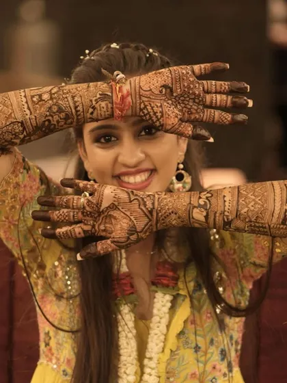 The joy of a bride flaunting her mehendi is everything. This beautiful shot captures the happiness and the intricate details of a full bridal design.