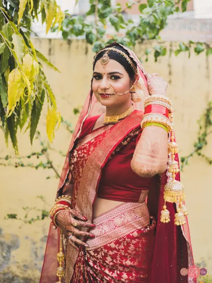 The bride, Aditi, looking radiant and happy in her traditional red wedding saree.