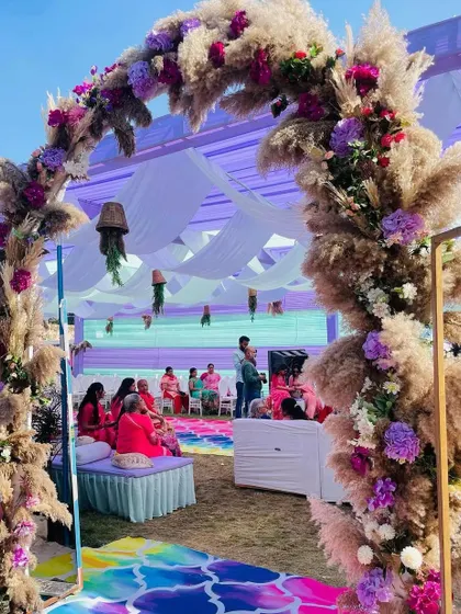An entrance arch for a Haldi ceremony made of pampas grass and purple flowers. The mix of textures and colors creates a beautiful boho-chic vibe.